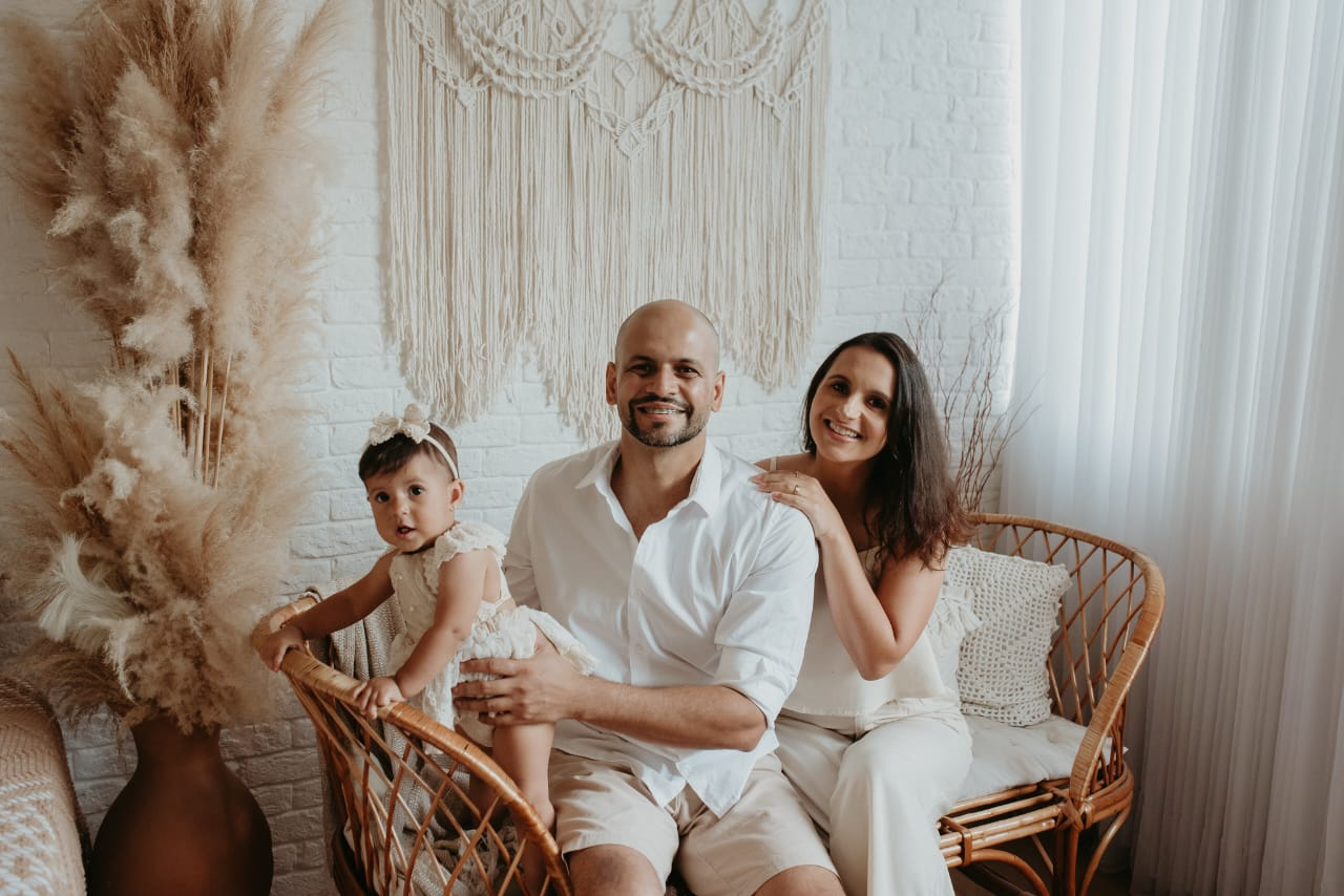 Franklin e Giselle com uma criança, juntos em uma fotografia de família.